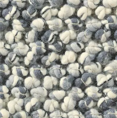 Colorful textured rug with yarn pom-pom details for stylish interior decor.