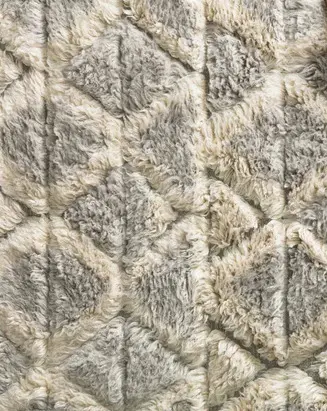 Luxurious beige and grey geometric patterned plush area rug with shag pile.