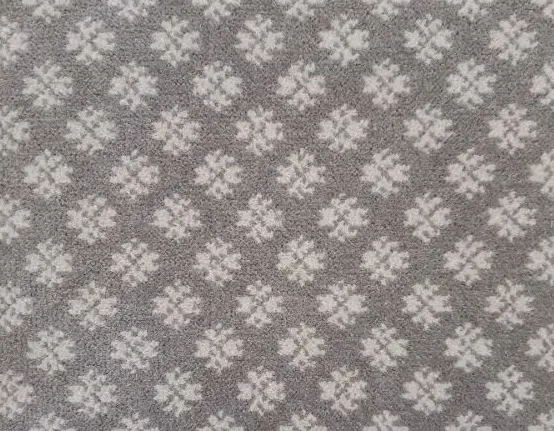 Soft gray carpet with white floral pattern, ideal for cozy home flooring and interior decoration.
