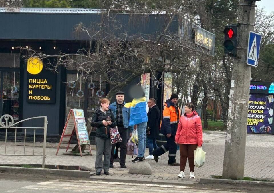 Зображення посту: В окупованому Маріуполі жінка ходила вулицею, огорнувшись в прапор України