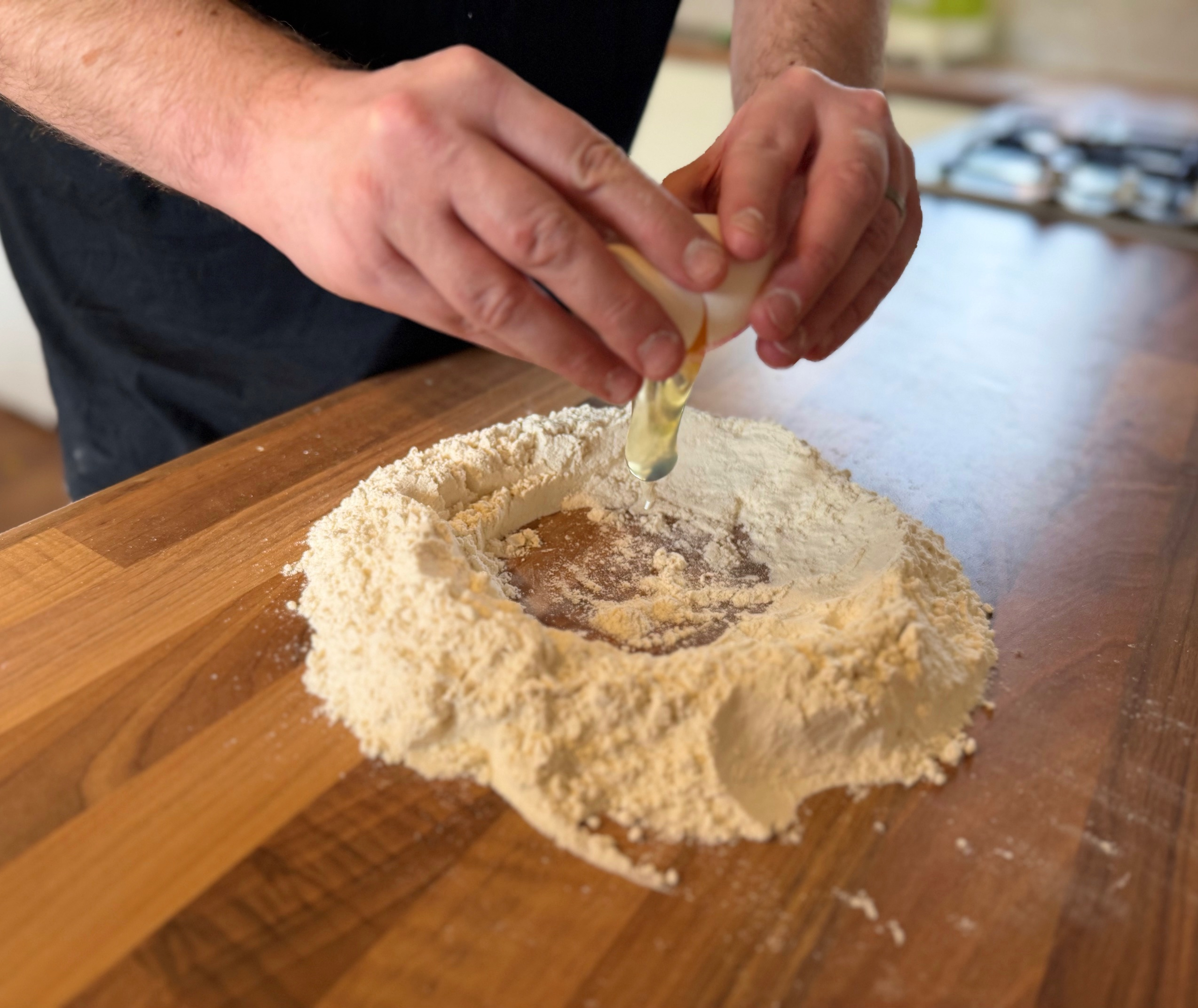 cracking eggs into flour