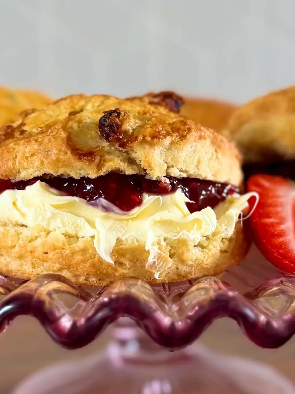 close up of scone with jam and clotted cream