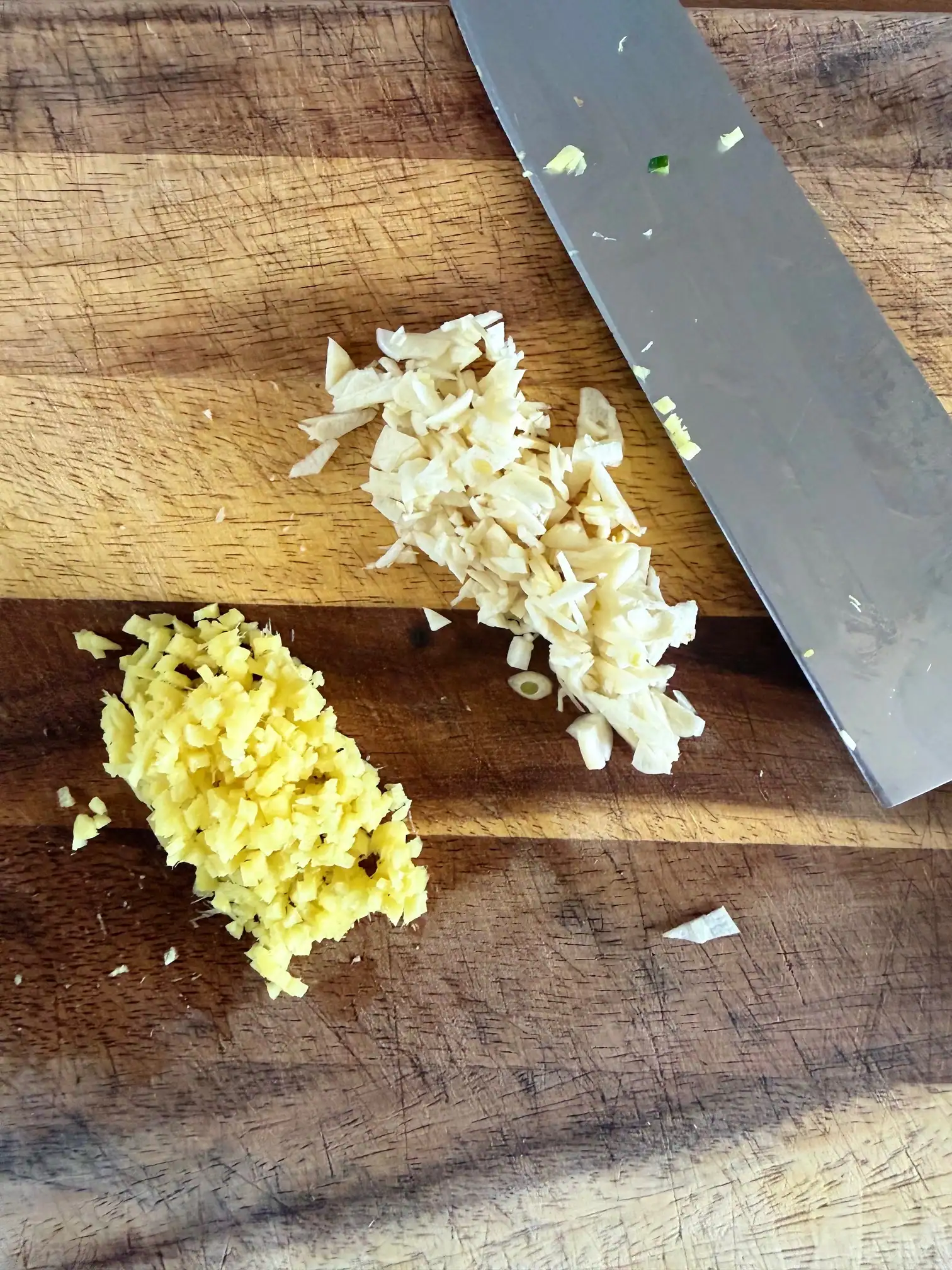 garlic and ginger chopped on a chopping board