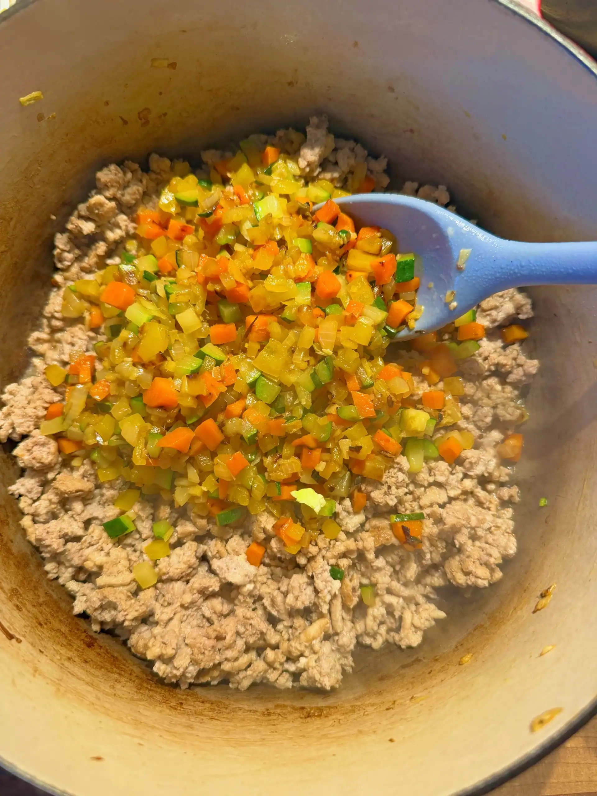 combining turkey and vegetables in a pan