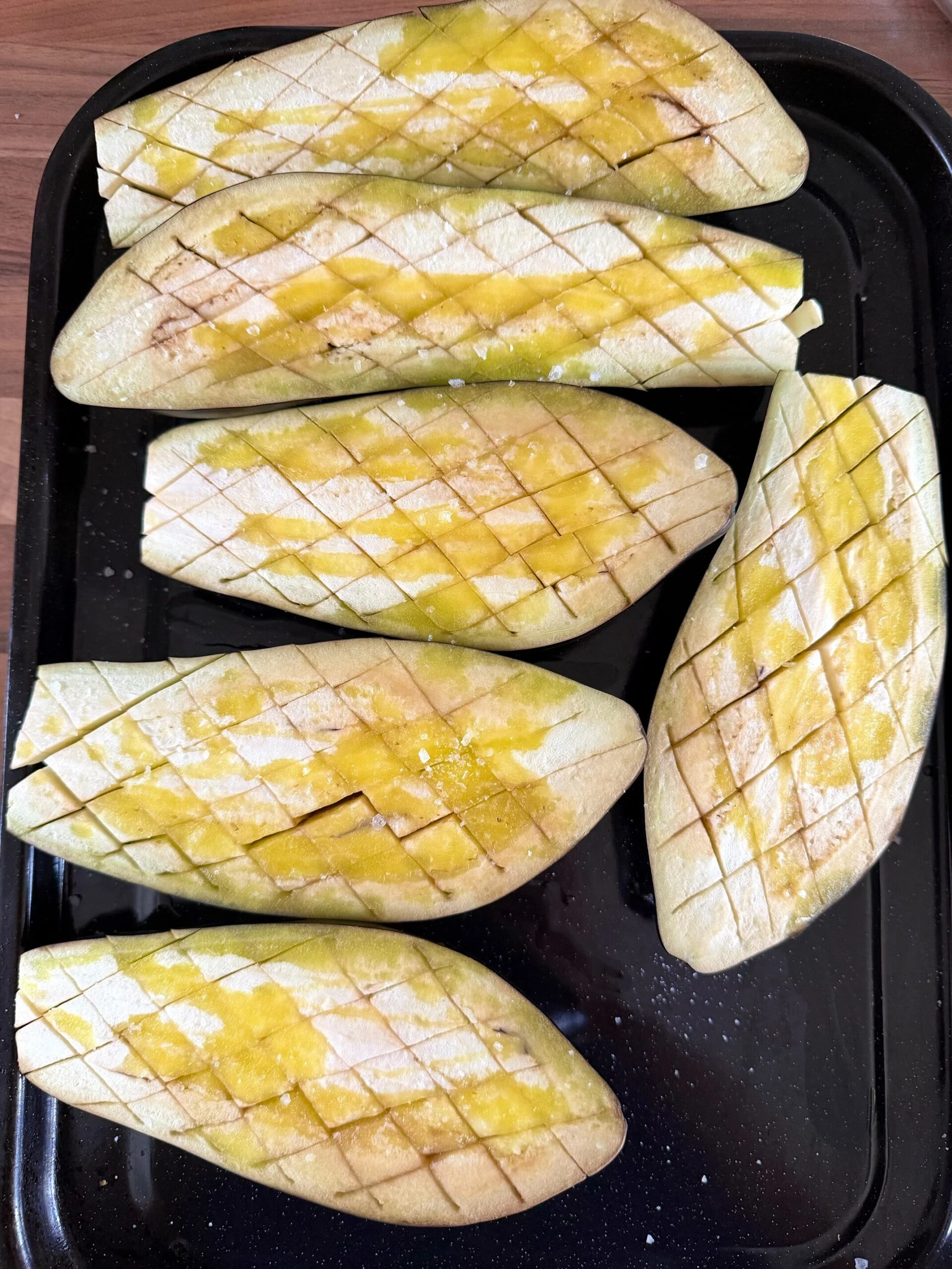 halved aubergines on a tray ready to roast