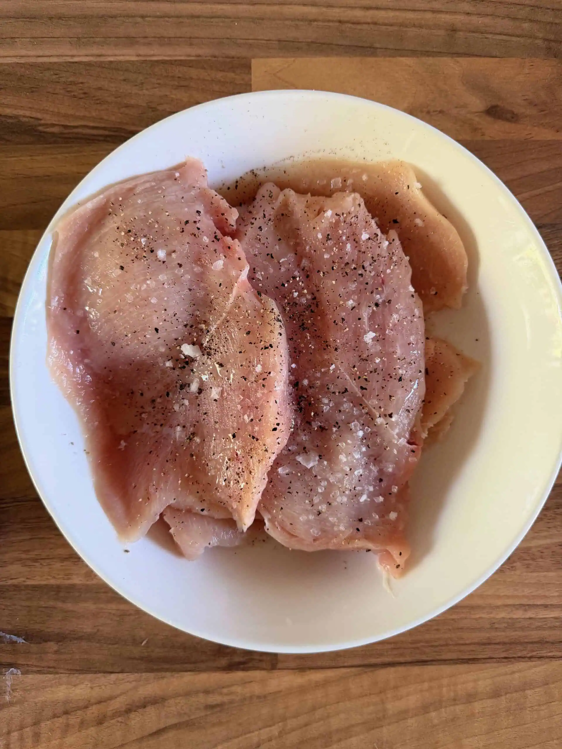 Sliced seasoned raw chicken in a bowl