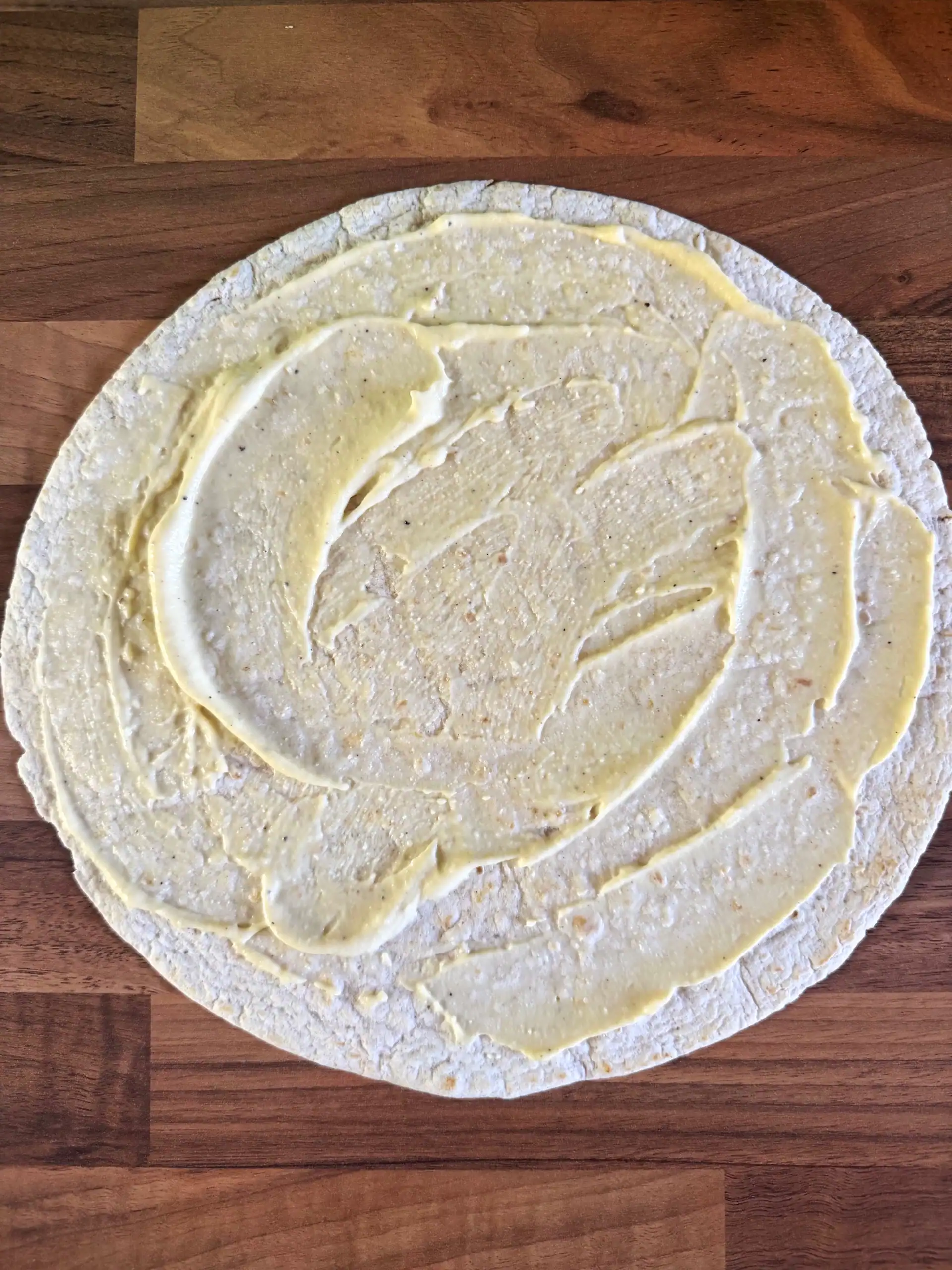 Spread Caesar dressing on wrap