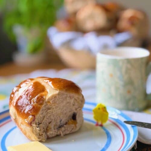hot cross bun on a plate with a yellow easter chick
