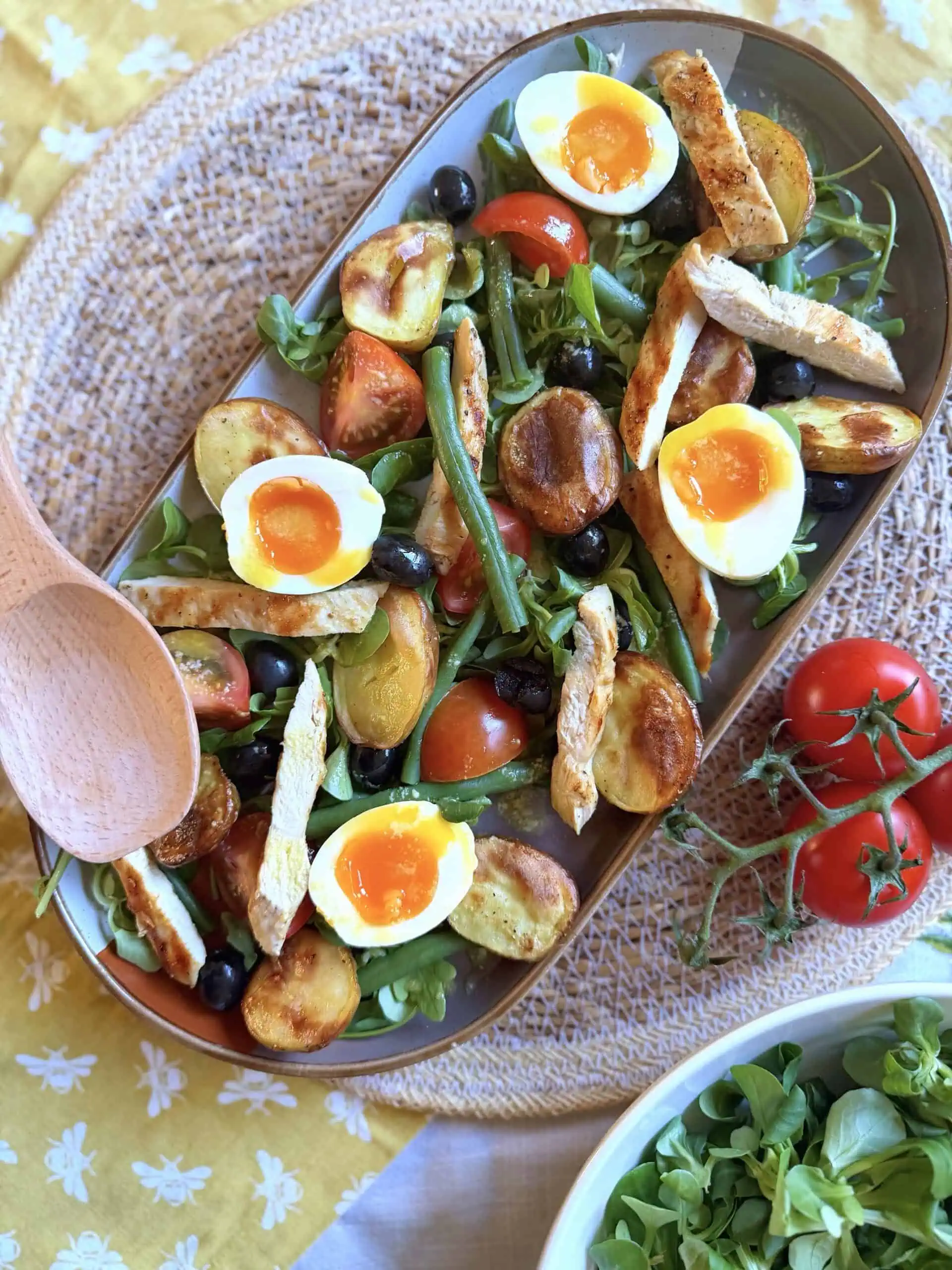 Chicken nicoise salad with wooden spoon