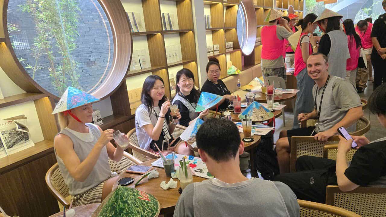 Tourists joining a Vietnamese conical hat painting workshop by Dasaque in Ho Chi Minh City