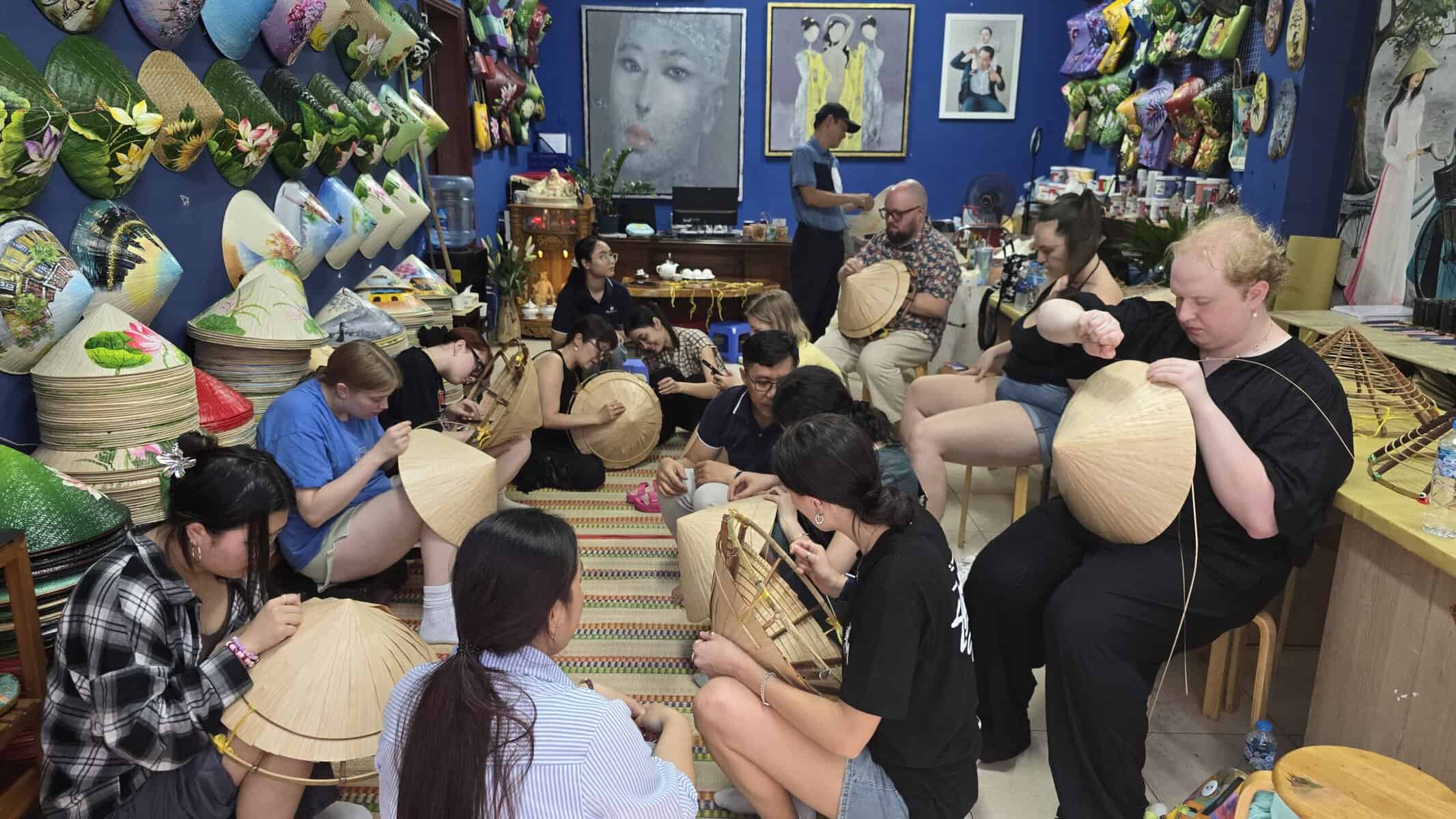 Travelers making Vietnamese conical hats during a Dasaque craft workshop in Ho Chi Minh City