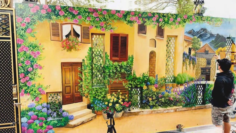 Vẽ tranh tường ngôi nhà và vườn hoa trên tường rào, họa sĩ vẽ tay trực tiếp tại công trình