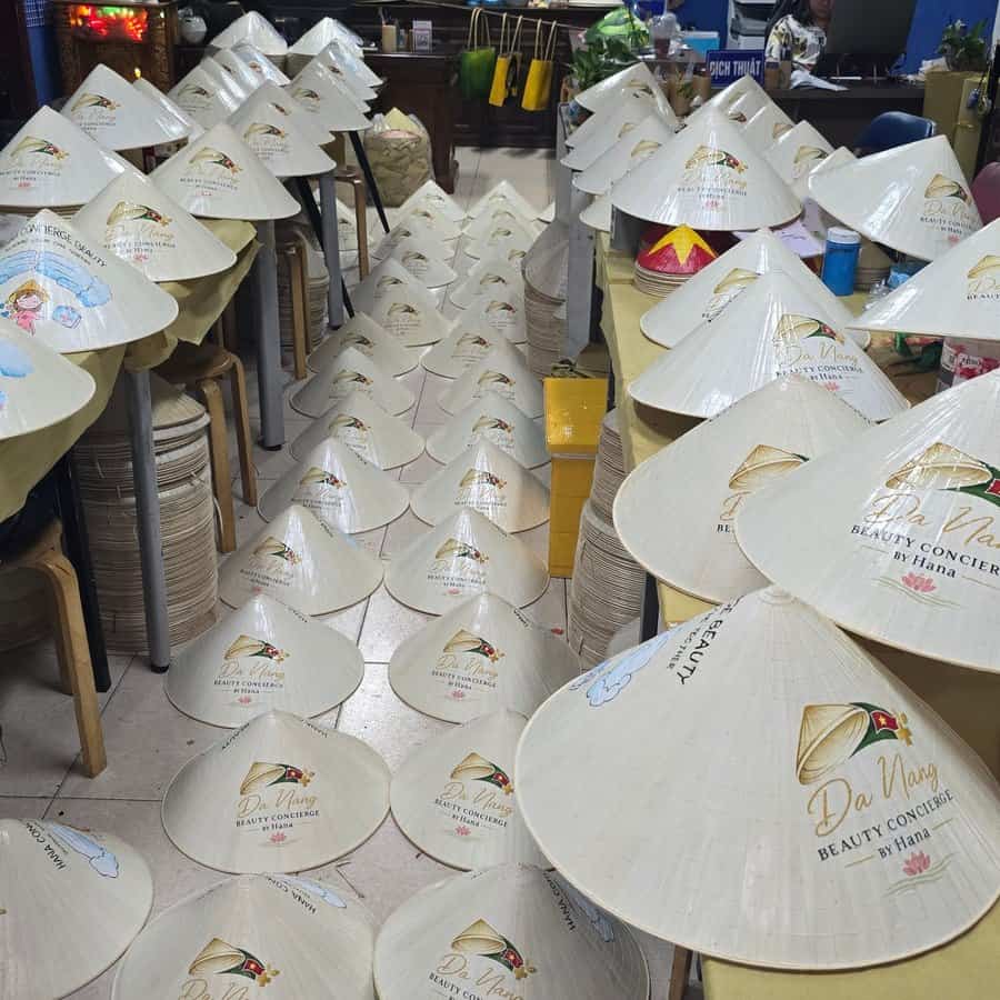 Xưởng in logo lên nón lá số lượng lớn với hàng trăm chiếc nón xếp dọc lối đi