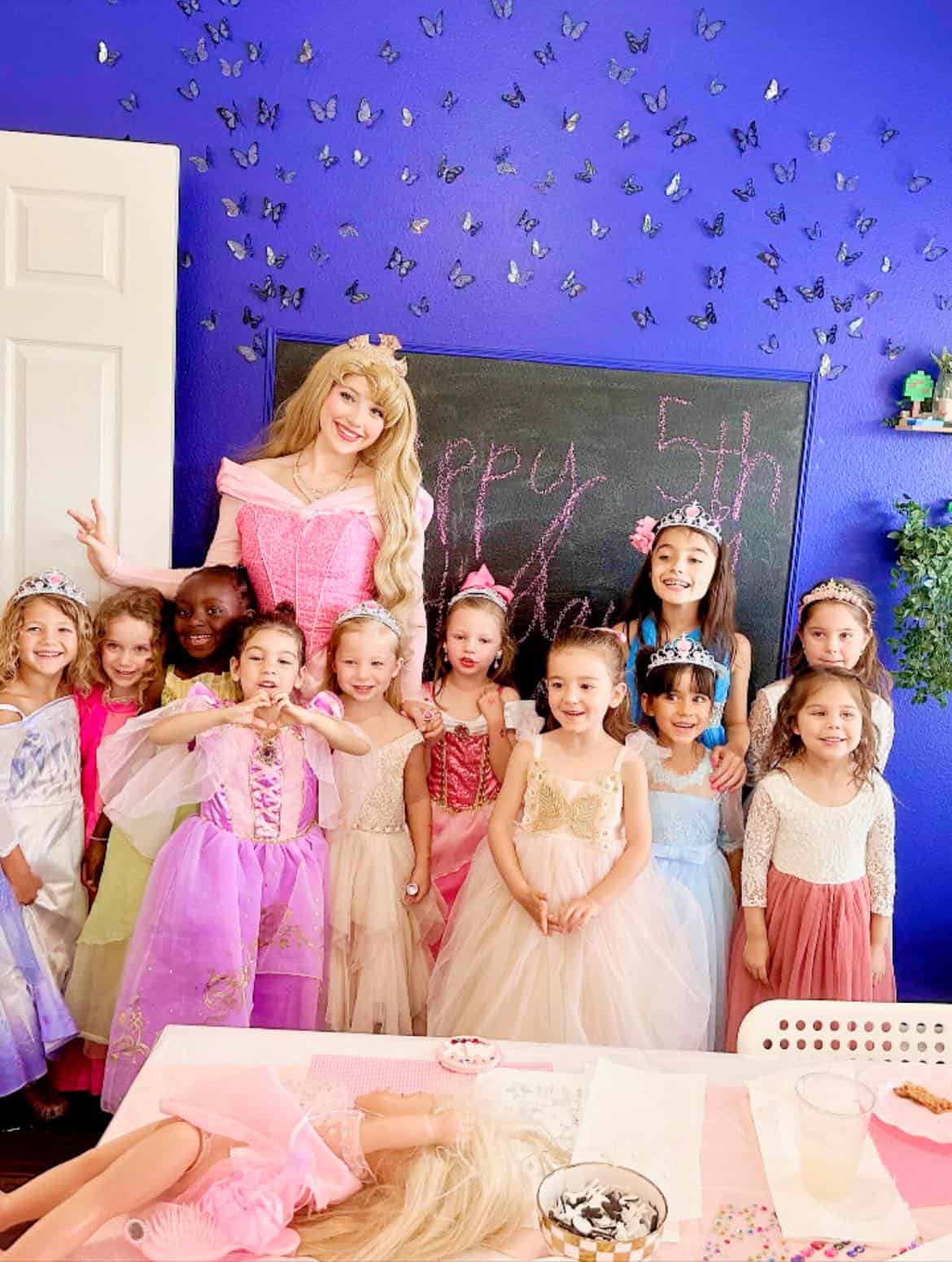 Children's birthday celebration with kids and fairy queen in colorful costumes.