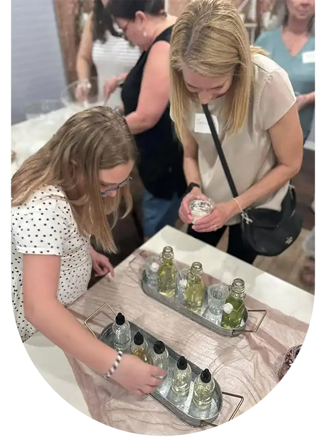 Elegant women exploring custom-themed perfume bottles.