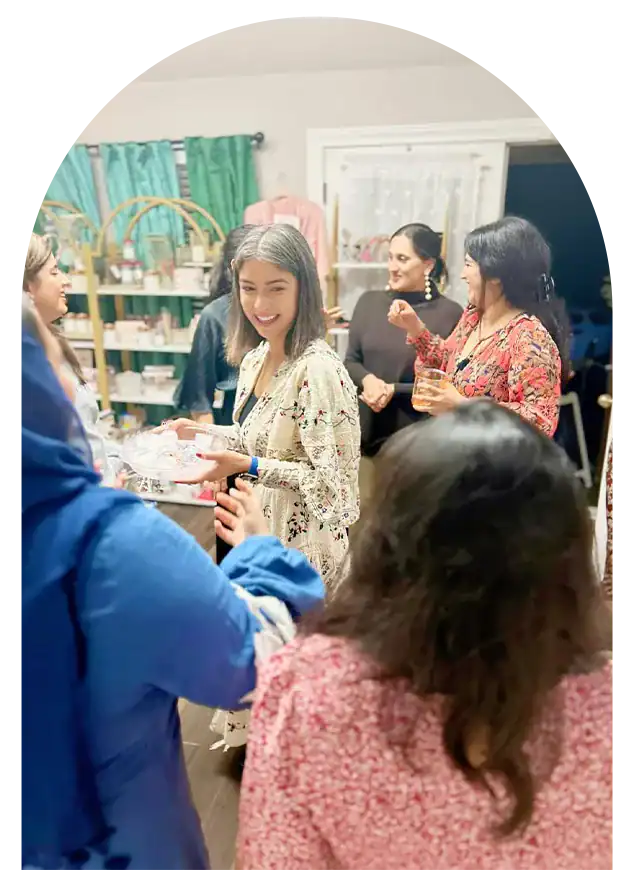 Happy women enjoying birthday party at Dax and Jade store, surrounded by friends and colorful decora.