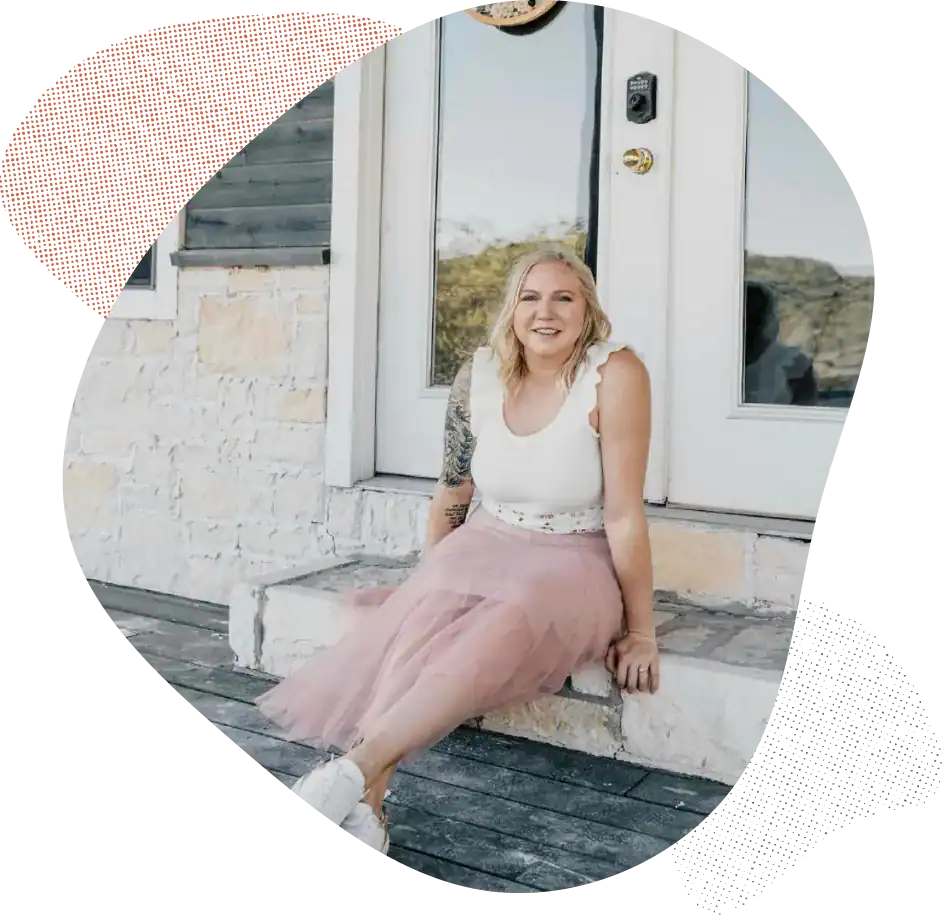 Woman sitting on front porch steps in casual outfit.