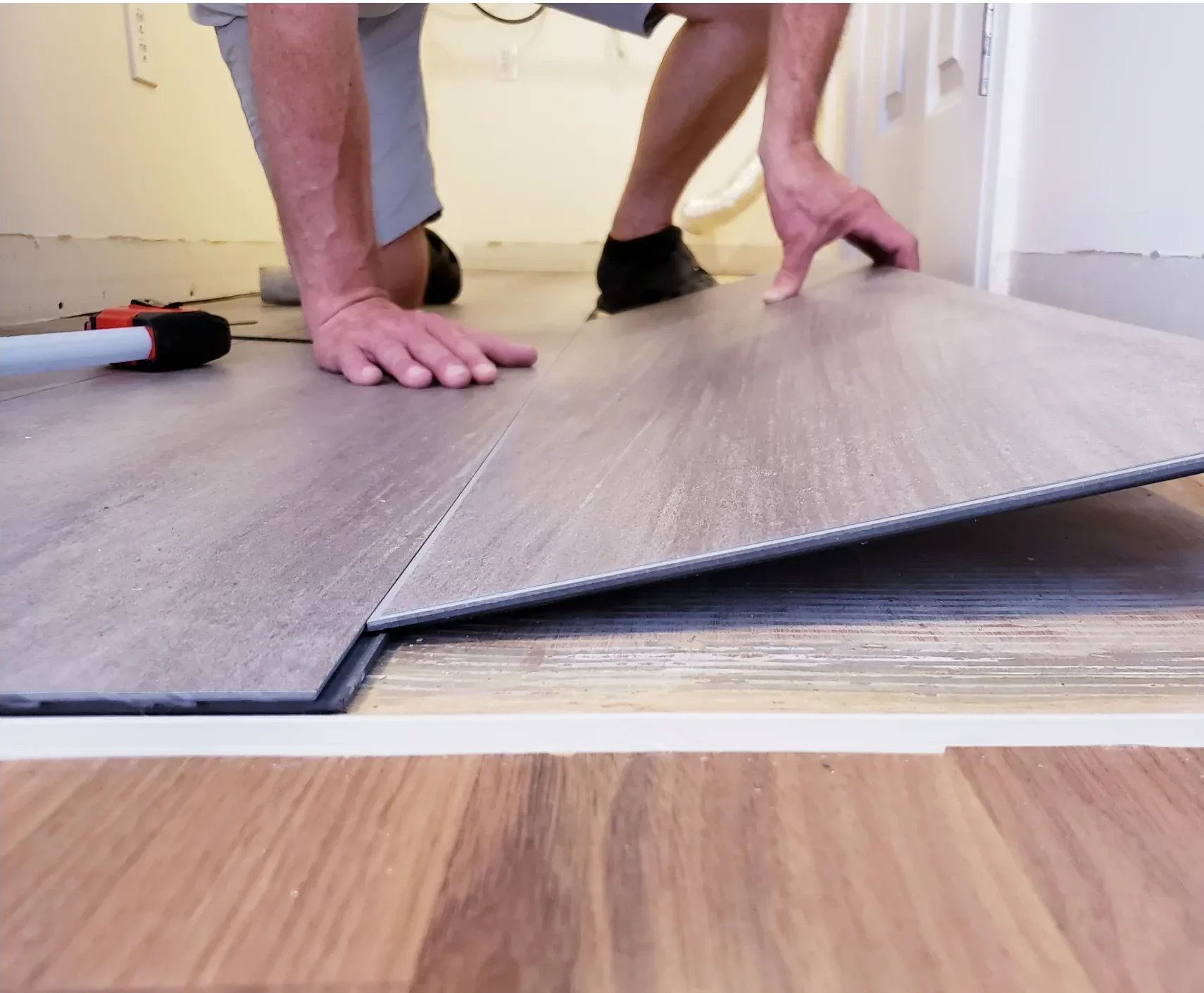New laminate flooring being installed by workers.