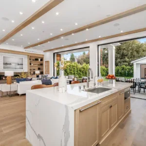 Modern open-plan kitchen and living room with outdoor patio view