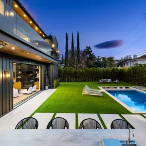 Modern house with a swimming pool and backyard at dusk