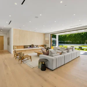 Modern living room with fireplace, large sofa, and open sliding doors to a backyard.