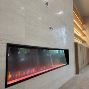 Modern electric fireplace with orange flames set in a light-colored stone wall.
