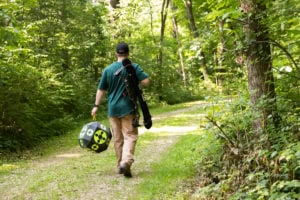 Man walks away from camera carrying a target and a Dead Ringer EZ Bow Sling