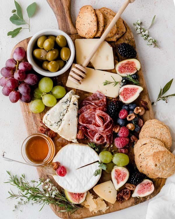 Creative charcuterie board ideas — beautiful grazing platter with cheeses, meats, fruit, nuts, and crackers for parties or cozy nights.