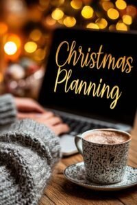 Christmas Planning Checklist image showing a cozy winter scene with a laptop, warm lights, a cup of cocoa, and a woman planning holiday tasks on her computer