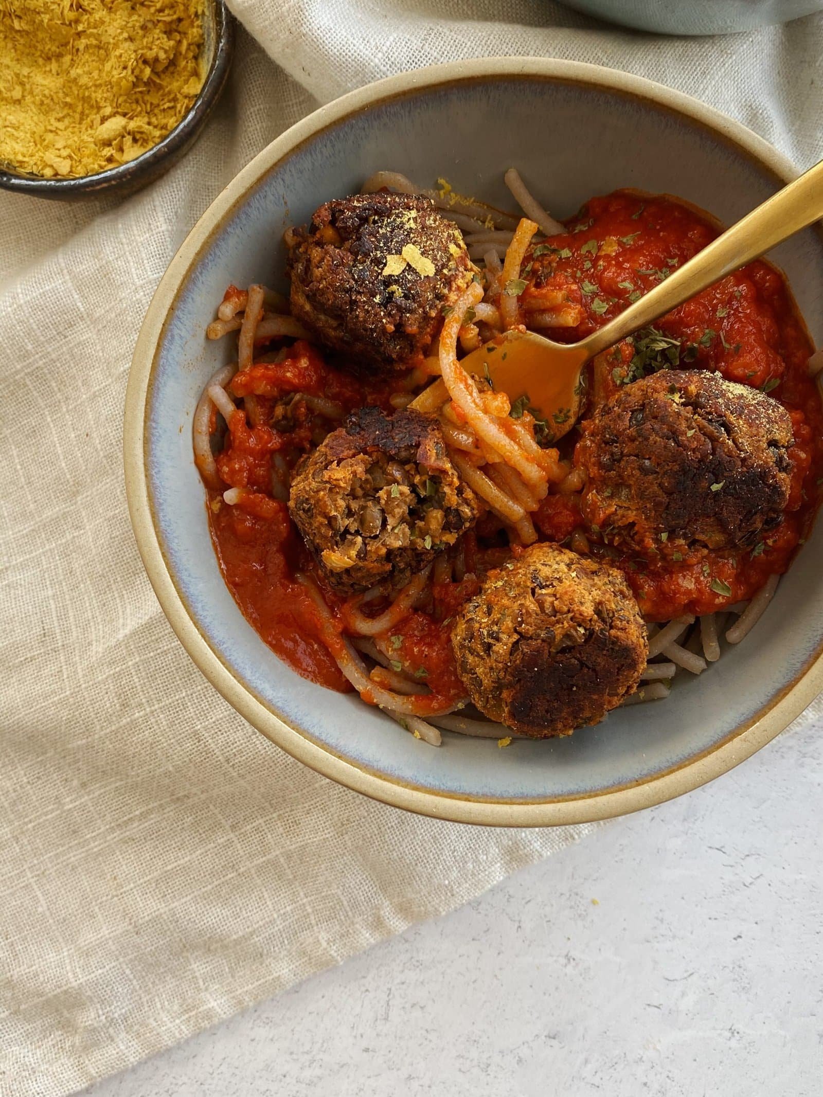 Vegan lentil meatballs served with sauce on a plate.