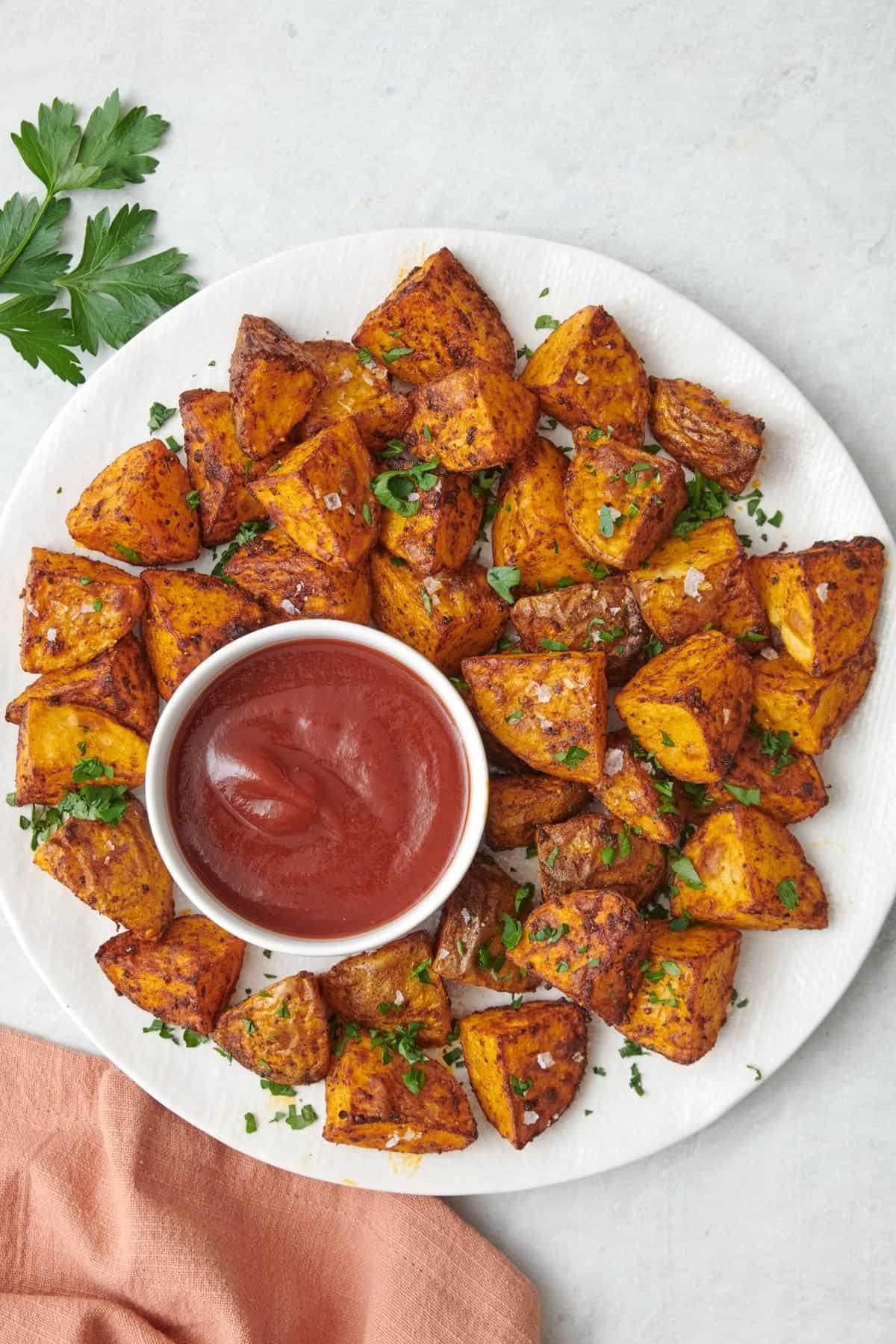 Crispy air fryer potato cubes served with ketchup for dipping.