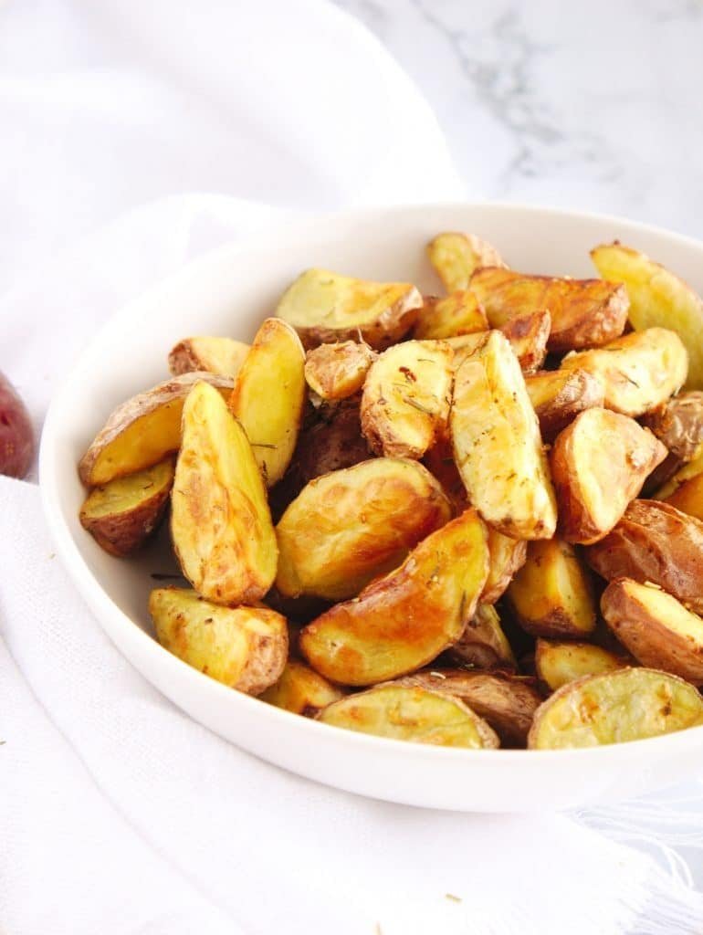 Crispy air fryer potato wedges served in a bowl.