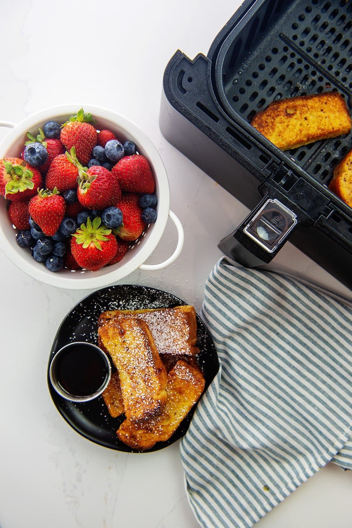 Air fryer French toast sticks on a plate.