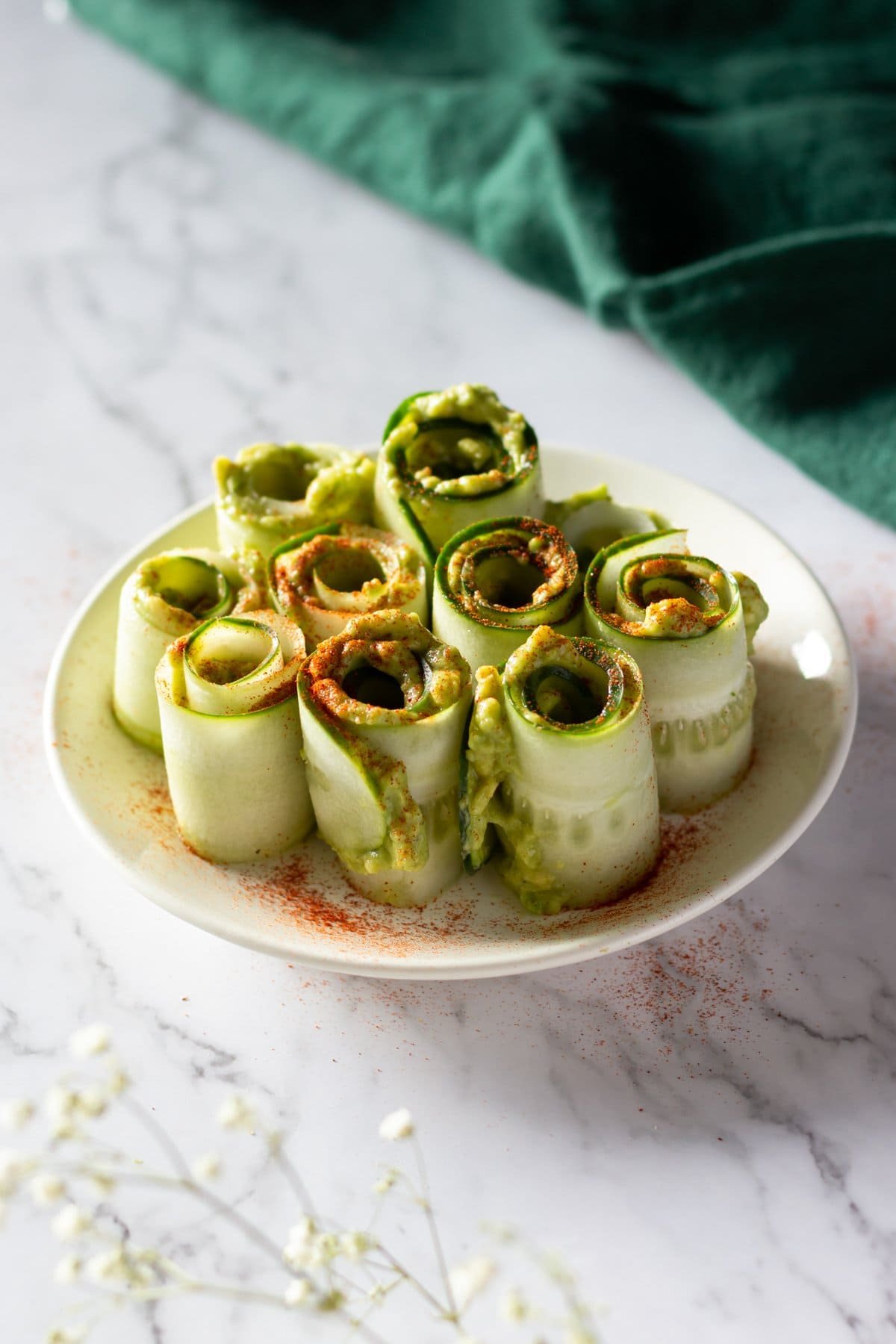 Cucumber and avocado rolls arranged on a plate.