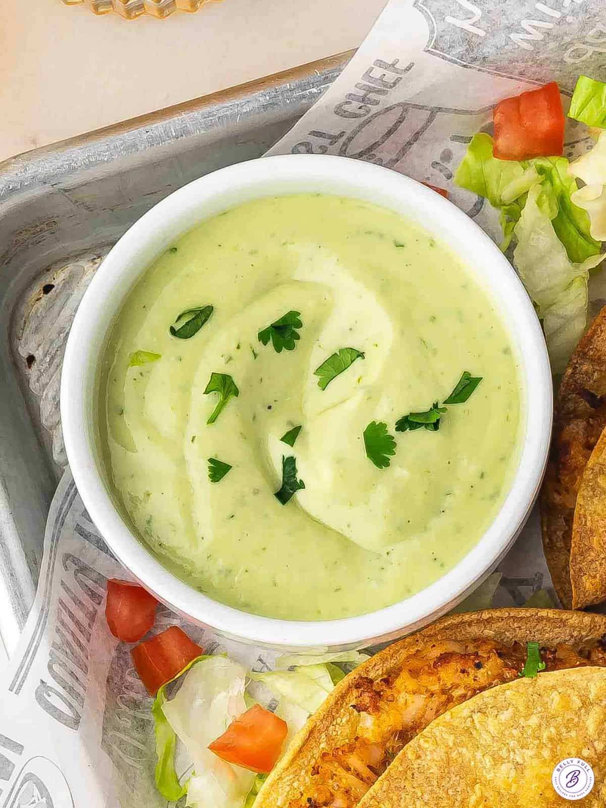 Creamy avocado lime sauce served with fresh lime and herbs