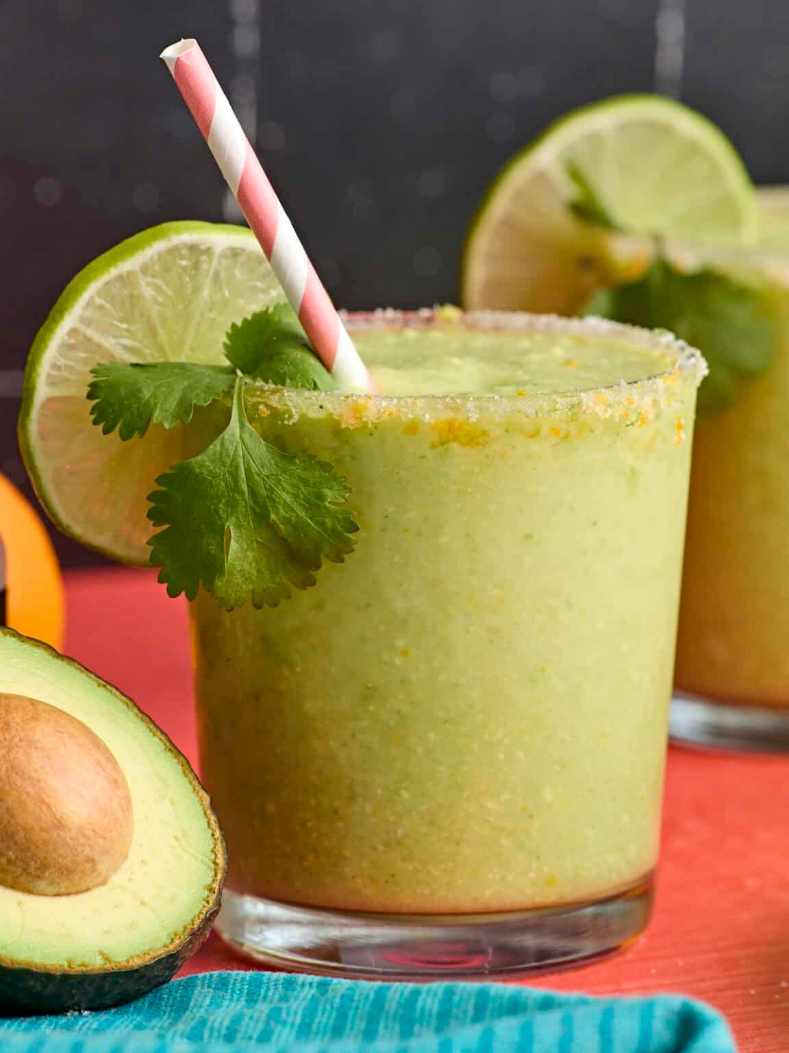 Creamy avocado margarita cocktail in a glass with lime