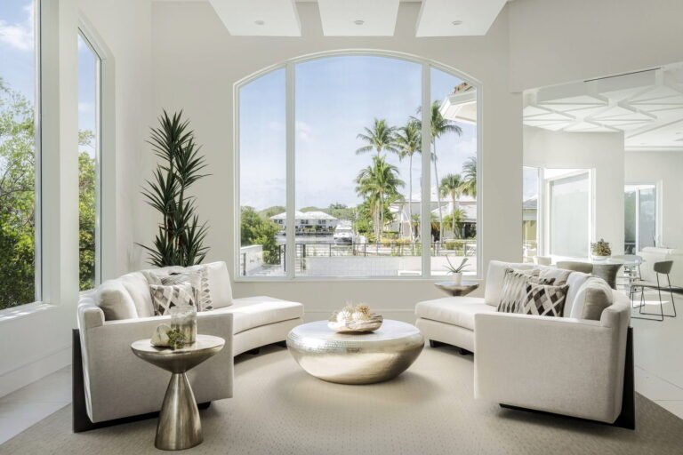 Bright coastal living room with large windows and modern white furniture in Boca Raton home