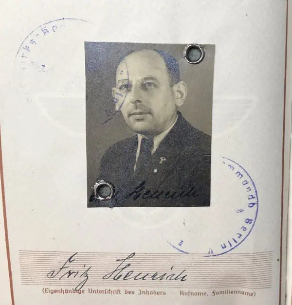 Authentic black-and-white photograph of a man with signature and official stamps.