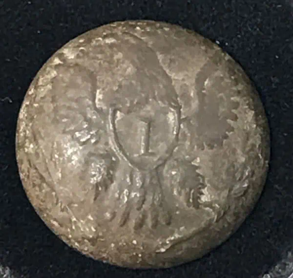 Antique coin with a detailed eagle and shield design, possibly Civil War era.