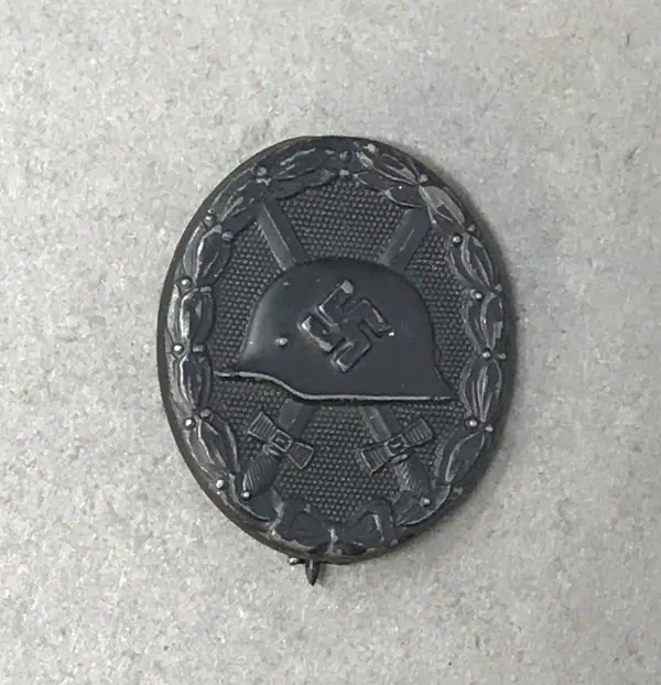 SS helmet with swastika emblem on a textured surface.