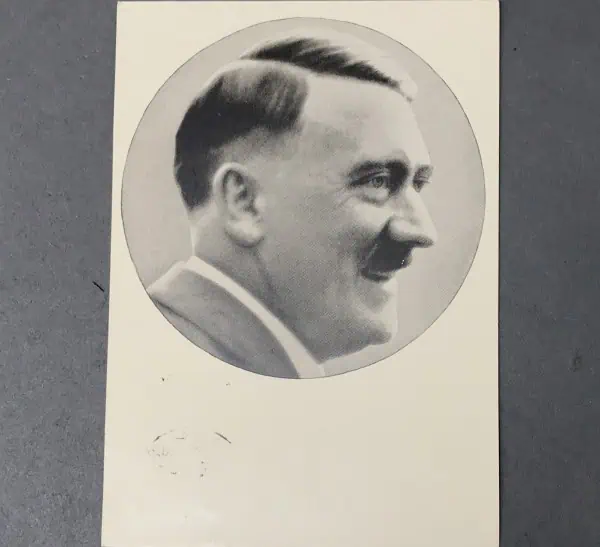 Vintage black and white portrait of a smiling man in profile, historical photograph.