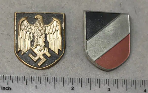 A detailed image of two military insignia badges, one featuring an eagle with swastikas and the othe.