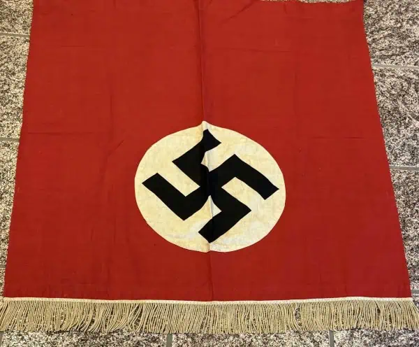 Nazis flag with swastika symbol on red fabric, historical artifact from World War II era.