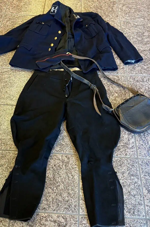 Civil War Union Army uniform with bag on tiled floor.