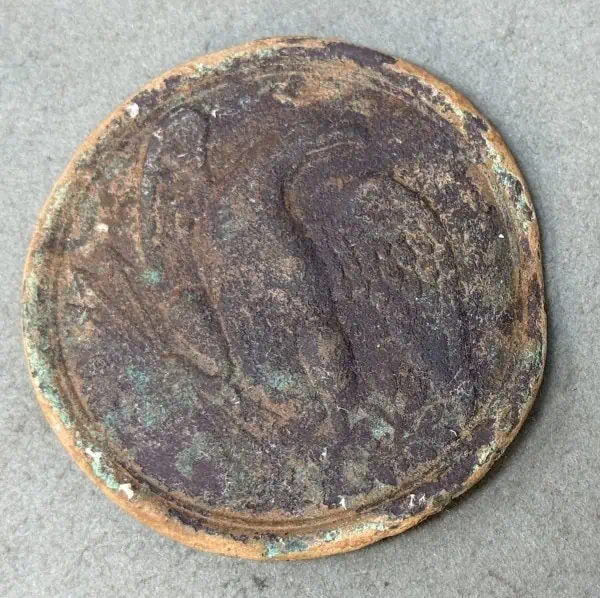 Ancient, corroded coin with worn surface and patina, historical artifact from Gettysburg Museum.