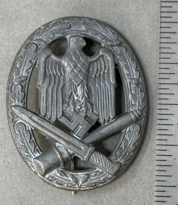 German WWII eagle badge with swastika, sword, and torch symbols.