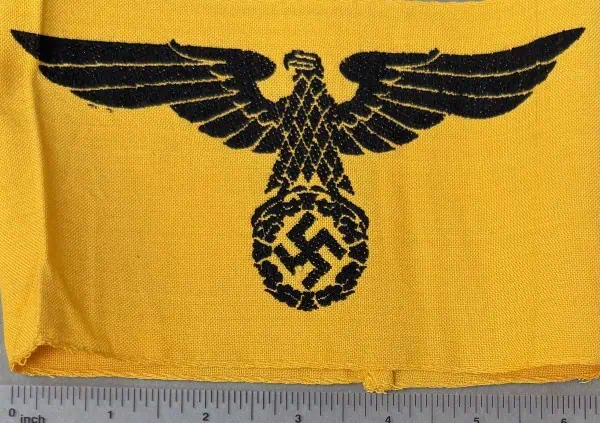 Nazi eagle insignia on yellow fabric, historical WWII symbol.