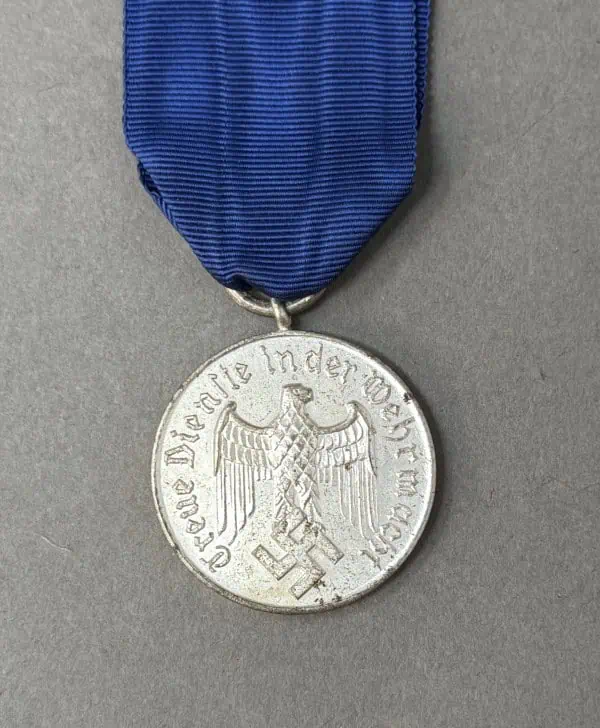 Medal with eagle and swastika from Nazi Germany, attached to a blue ribbon.