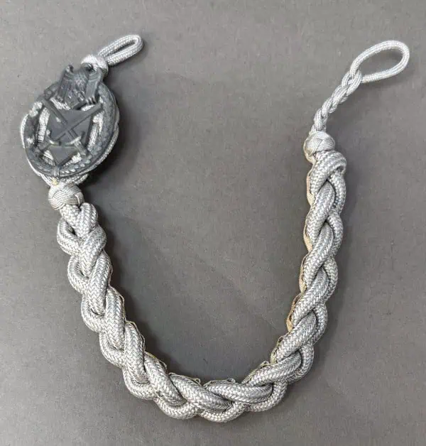 Silver braided necklace with a military emblem pendant on a gray background.