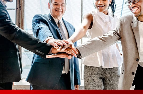 Business team forming a handshake alliance in a modern office environment.